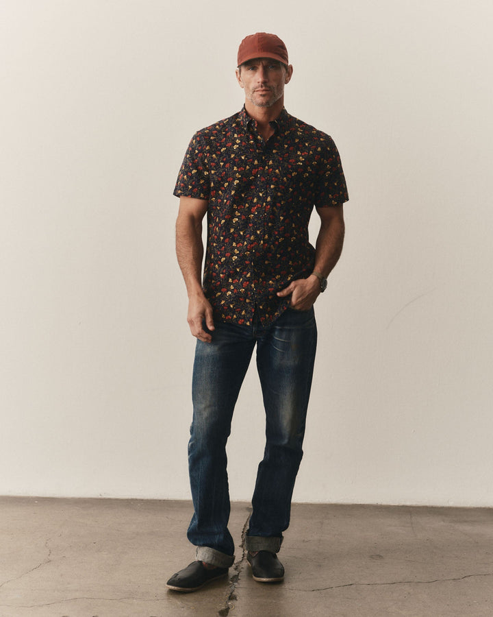Man wearing The Short Sleeve Jack
in Vintage Bloom, jeans, and a cap against a plain background