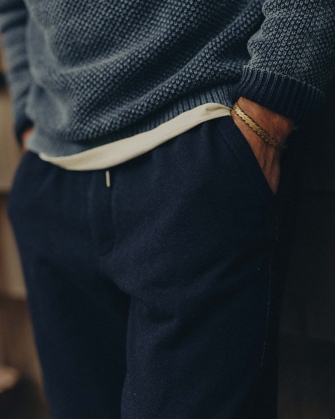 Person wearing a dark blue knitted sweater and Taylor Stitch&