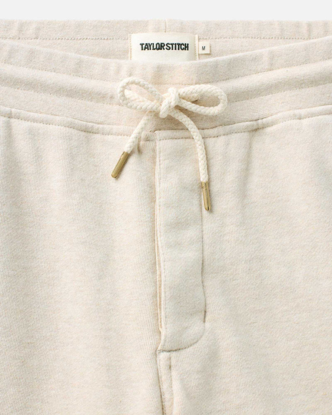 Close-up of The Sunset Short
in Heather Oat Terry with a drawstring and Taylor Stitch label.