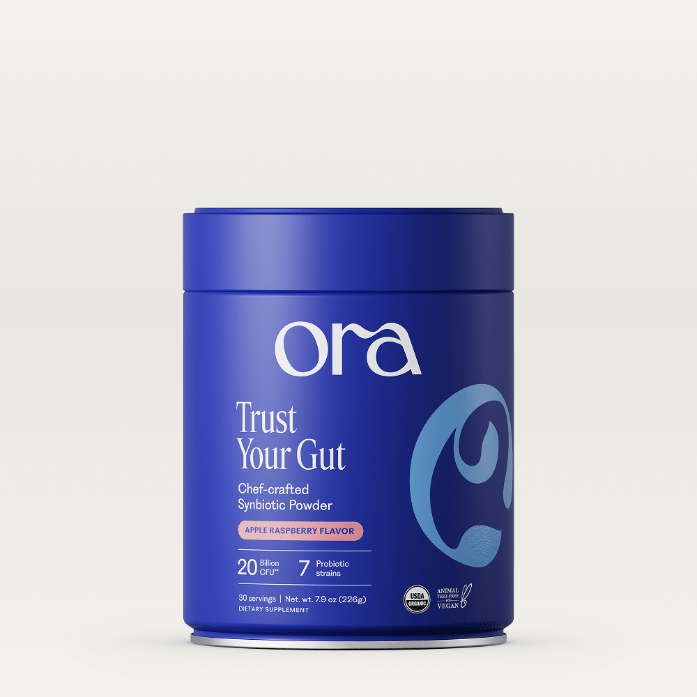 Blue container of Ora Trust Your Gut powder on a light gray background