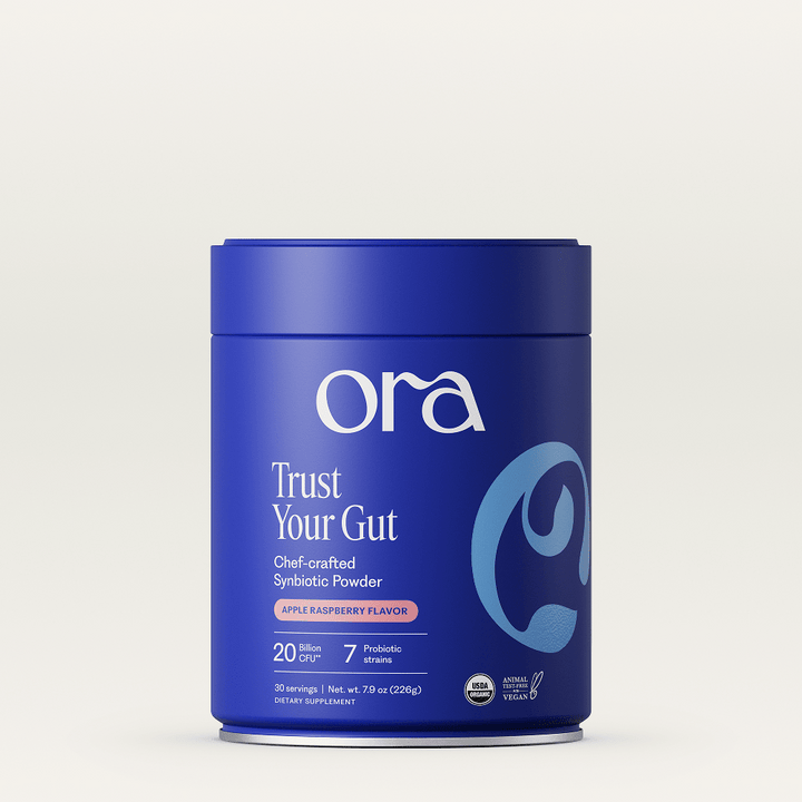 Blue container of Ora Trust Your Gut powder on a light gray background
