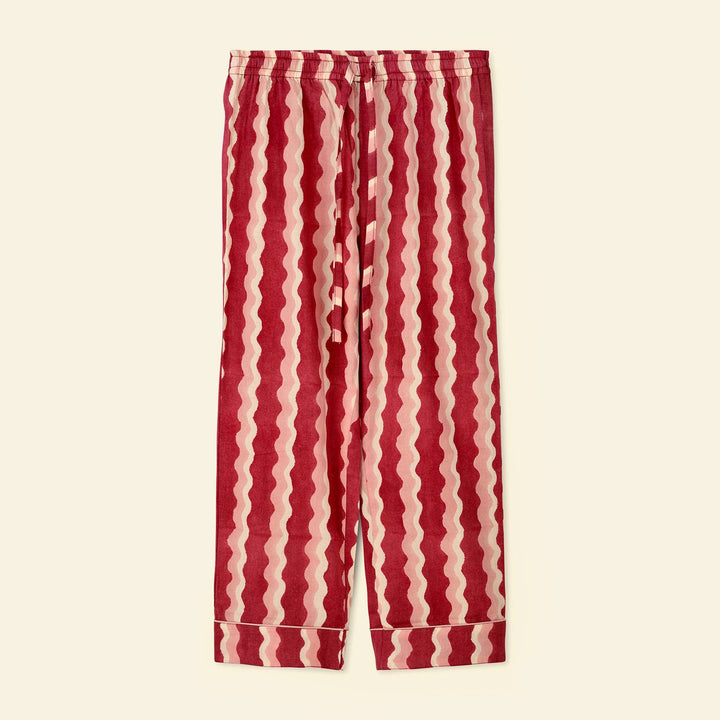 A pair of Yonder pajama bottoms featuring a vertical wavy stripe pattern in deep red and light pink, laid flat against a solid cream background.