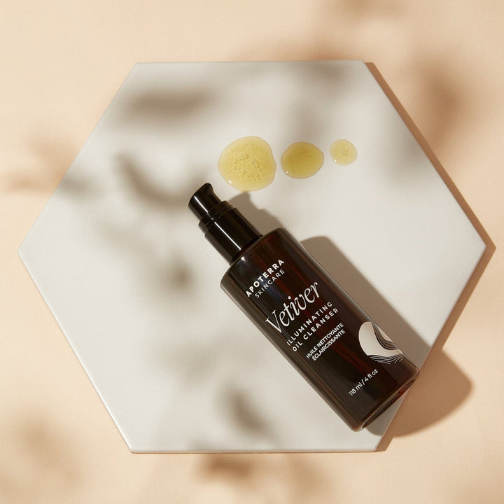 Brown bottle of Vetiver oil cleanseron a beige hexagonal plate with dots of cleanser.