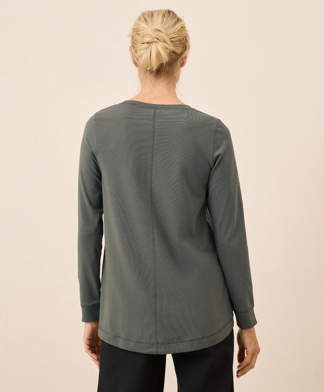 women wearing a green long-sleeve shirt on a beige background