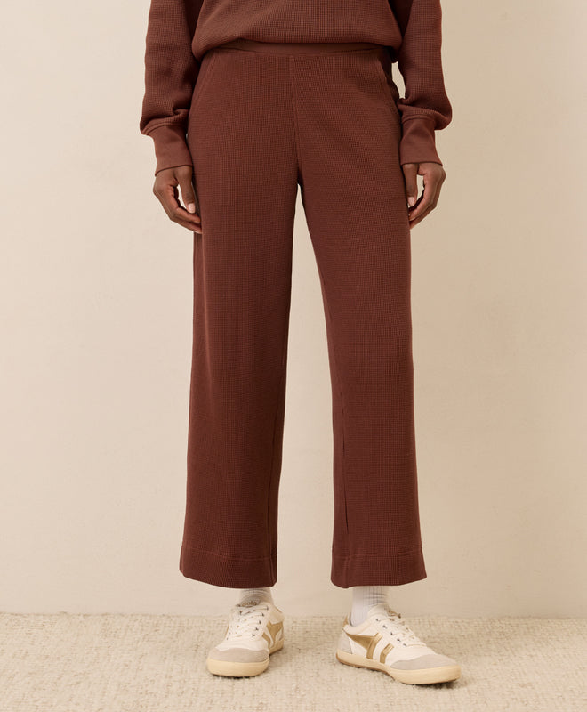 Brown waffle pants worn by a women on a beige background