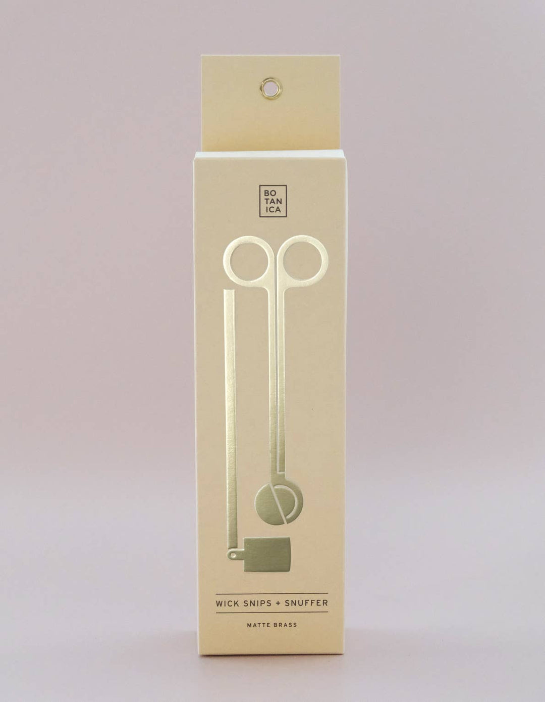 Beige packaging box with wick snips and snuffer illustration on a light gray background