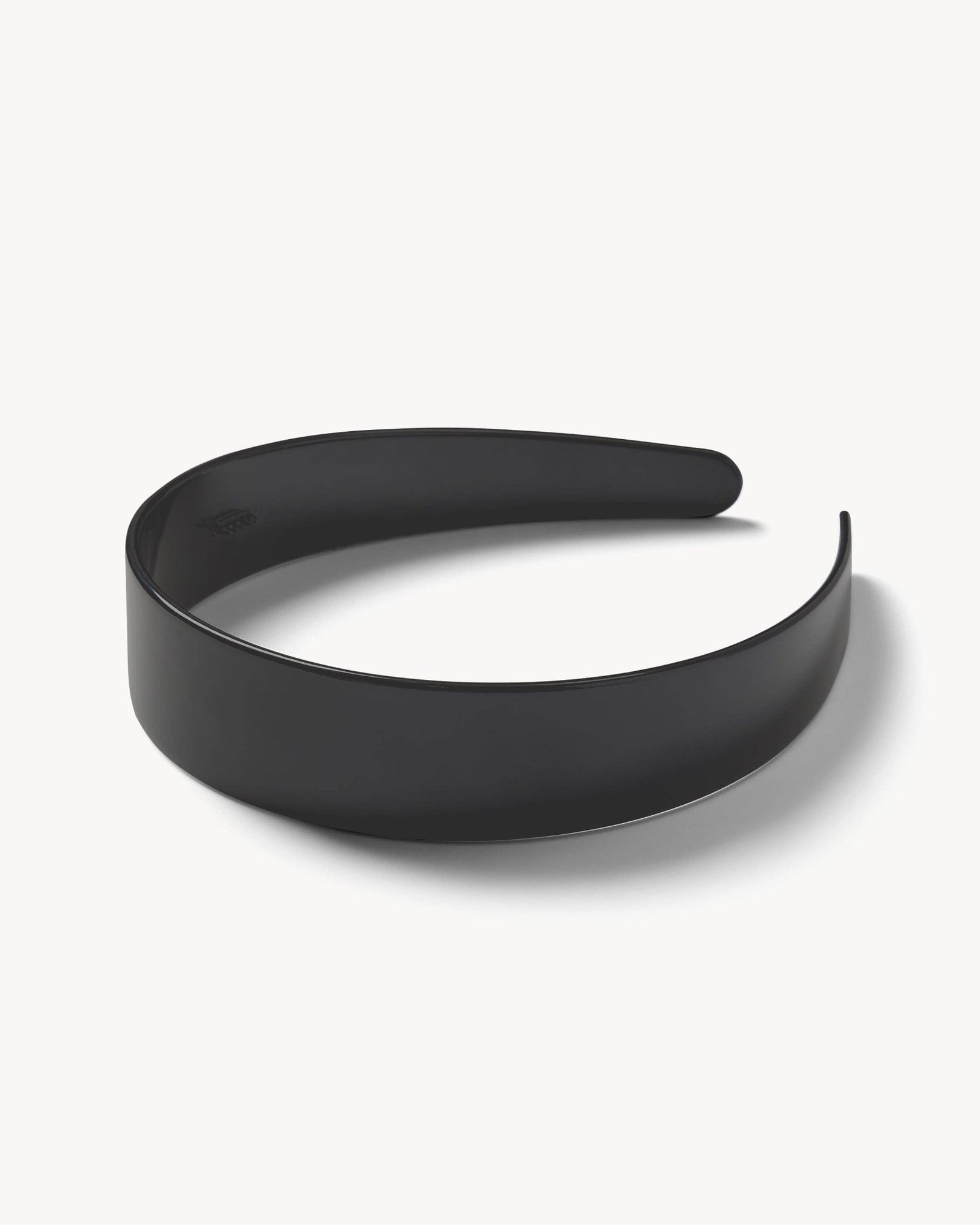 Machete's wide headband in black on a white surface.