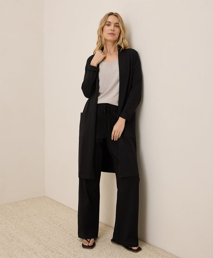 Woman wearing a black outfit against a plain background