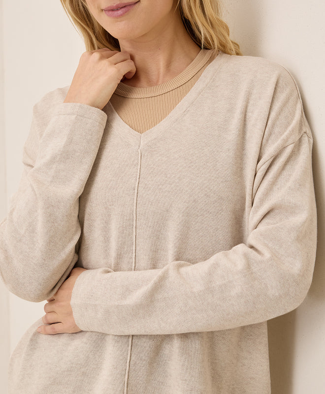Beige long-sleeve dress worn by a person against a neutral background