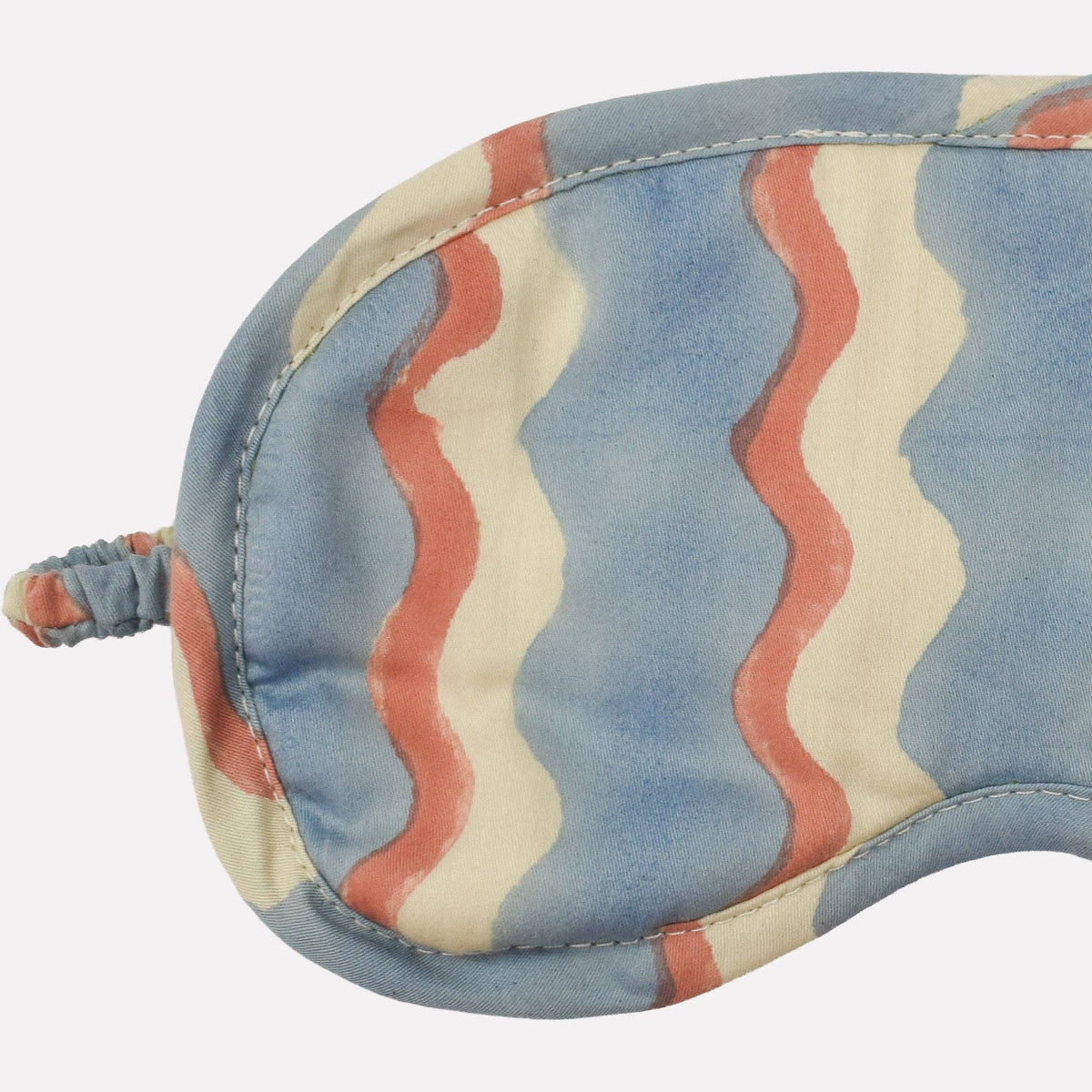 Yonder striped eye mask with blue, red, and beige pattern on a white background