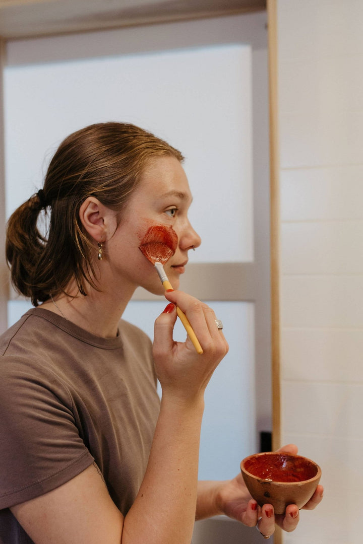 Flowers & Rose Clay Botanical Face Mask - 1 oz - Shown on a model as she applies it to her face - Echo Market