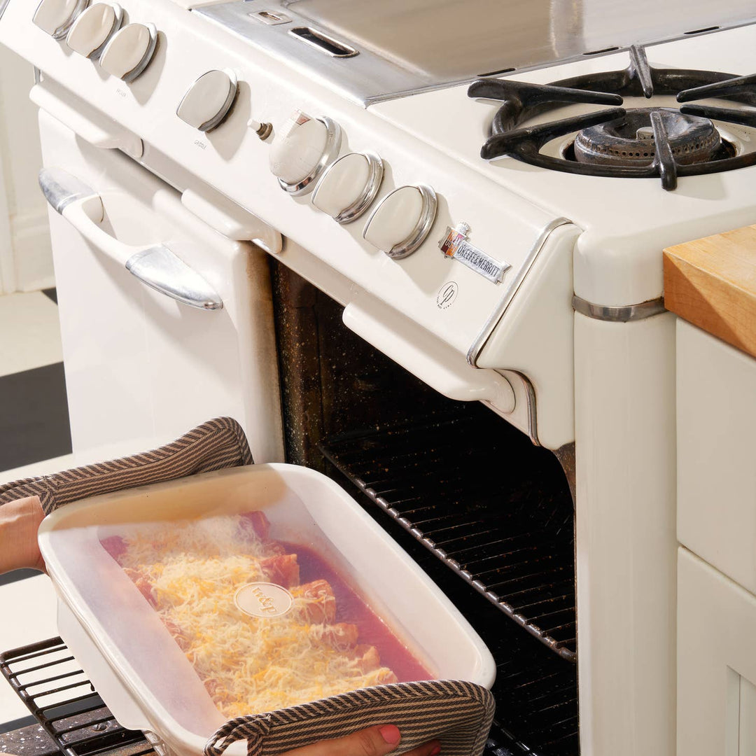 Silicone Stretch Baking Lids Set - Displayed covering a tray of food as it is loaded into an oven - Echo Market